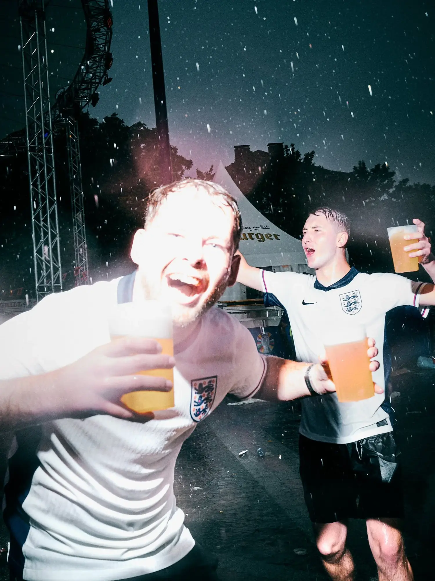 Zwei junge Maenner feiern im Regen